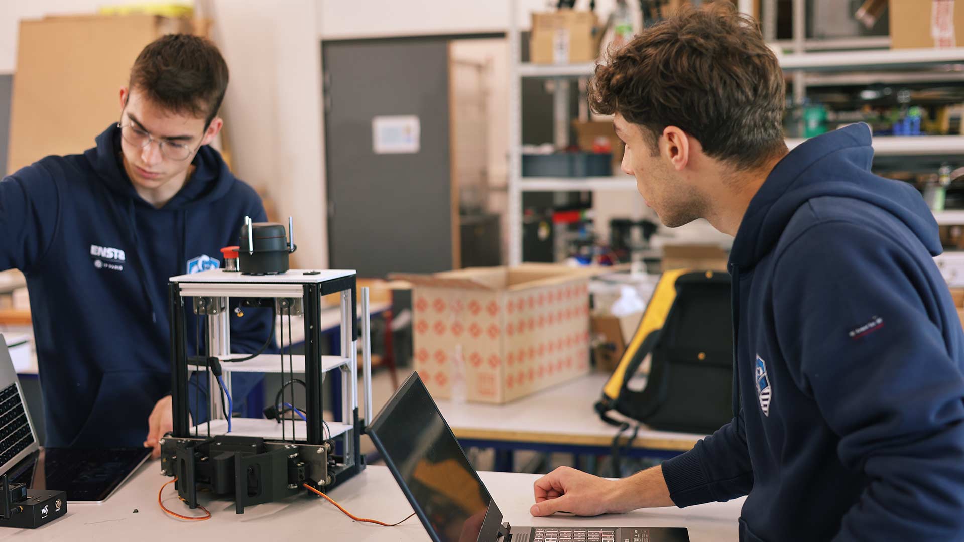 Deux étudiants de l'ENSTA travaillant sur leur robot en vue de la coupe de France de robotique