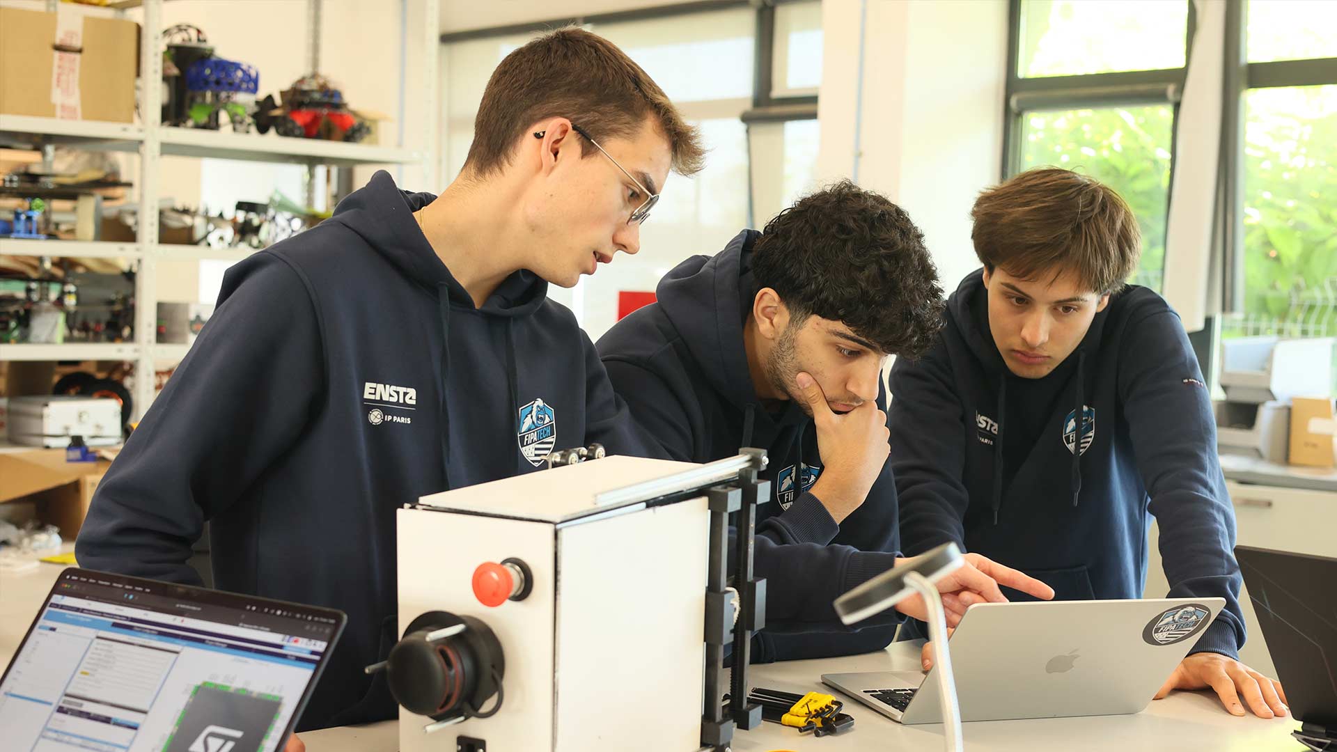 Trois étudiants de l'ENSTA qui travaillent sur leur robot en vue de la coupe de France de robotique